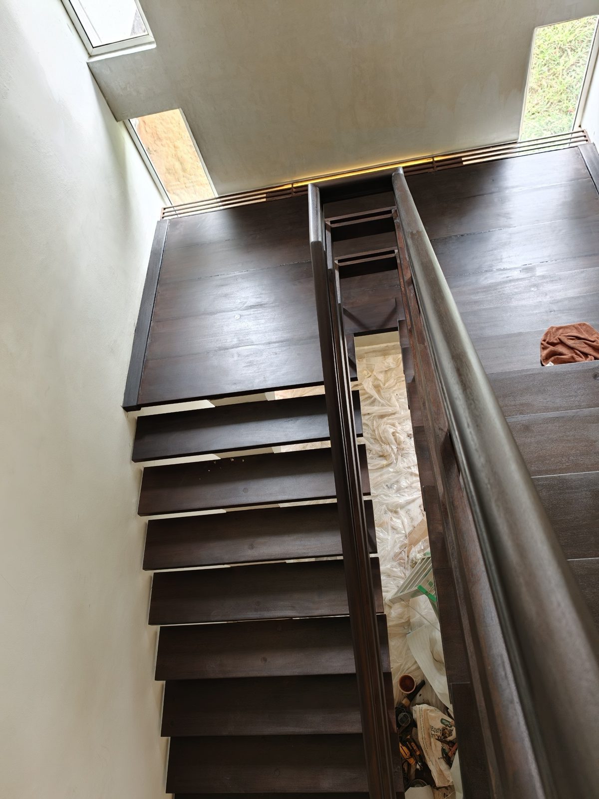 View from the upper landing down a refinished solid timber staircase in a Damansara Heights bungalow