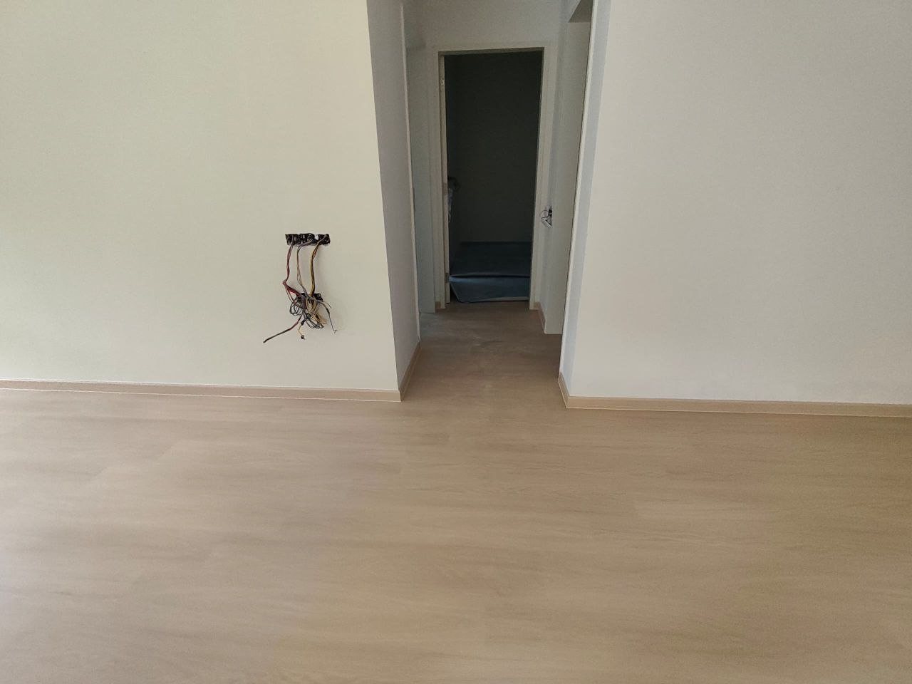 Scarlet Oak SPC flooring laid over old tiles in a D'Clover Residences condo, looking down the hallway toward a bedroom
