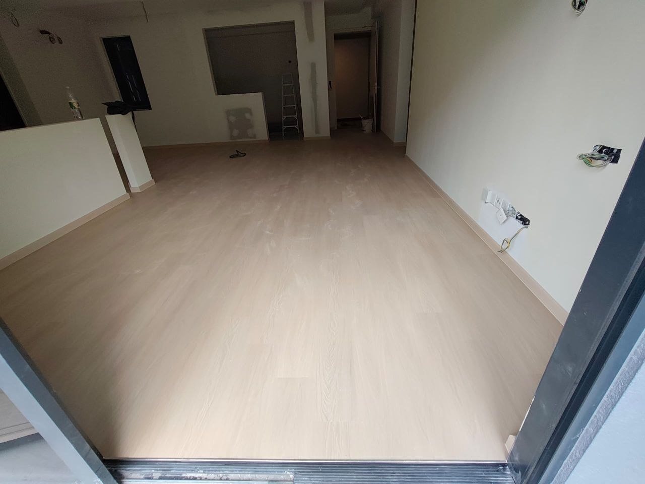 Wide light oak-look SPC floor across the living and dining area of a D'Clover Residences unit, Damansara Perdana