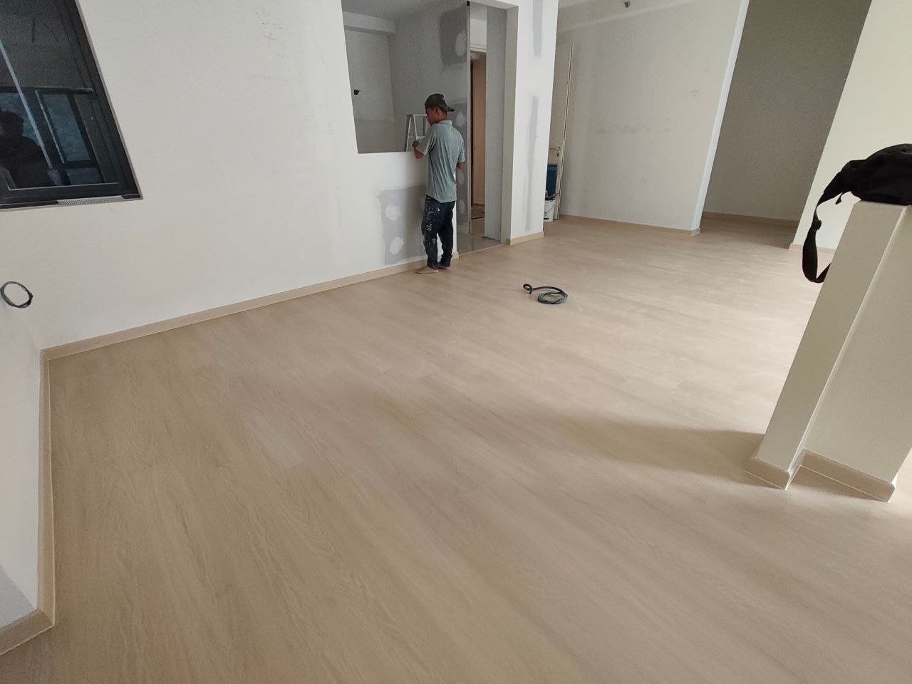 Open living area with continuous light oak-look SPC flooring and matching skirting in a D'Clover Residences condo